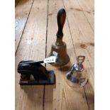 An old school bell with turned wooden handle, a silver plated table bell and an old embosser