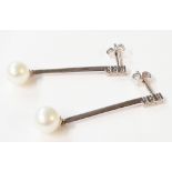 A pair of 585 (14ct.) white gold drop earrings, each set with three tiny diamonds to top of bar