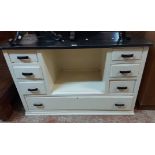 A 1.14m 20th Century drawer unit with later black ash effect top, bakelite handles and central