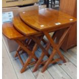 A nest of three stained hardwood tea tables, set on X-frame standard ends