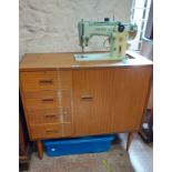A retro teak effect cabinet cased Singer sewing machine
