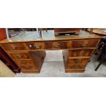 A 1.37m reproduction mahogany twin pedestal desk with green leather inset top, three frieze