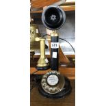 A reproduction candlestick telephone with black japanned body and brass fittings