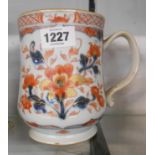 An antique Chinese porcelain tankard with iron red and cobalt blue floral panel decoration with gilt