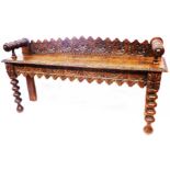 A 1.2m 19th Century carved oak window seat with decorative back rail, solid seat and flanking