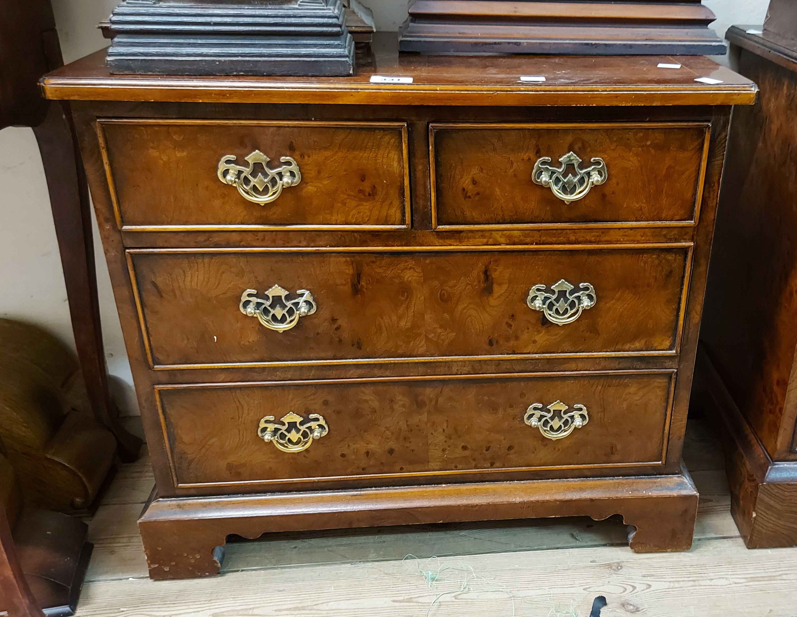 A 66cm reproduction burr walnut quarter veneered low chest of two short and two long drawers with