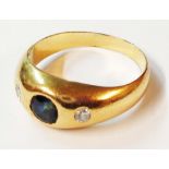 A marked 750 yellow metal gypsy set ring with central sapphire flanked by two tiny diamonds - size