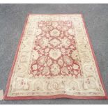 A late Chinese washed wool rug with faded foliate decoration on red ground - 1.8m X 1.2m