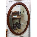 Three assorted wall mirrors comprising an Edwardian inlaid framed bevelled oval, a vintage frameless