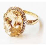 A 750 (18ct.) gold ring, set with large central oval canary kunzite within a diamond border - size O