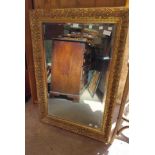 A reproduction gilt framed bevelled oblong wall mirror with decorative border - 76cm X 1.05m