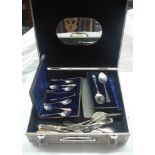 An aluminium case containing a small quantity of cased and loose silver plated cutlery