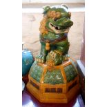 A large 20th Century Chinese pottery figurine depicting a temple lion sat on a domed plinth with