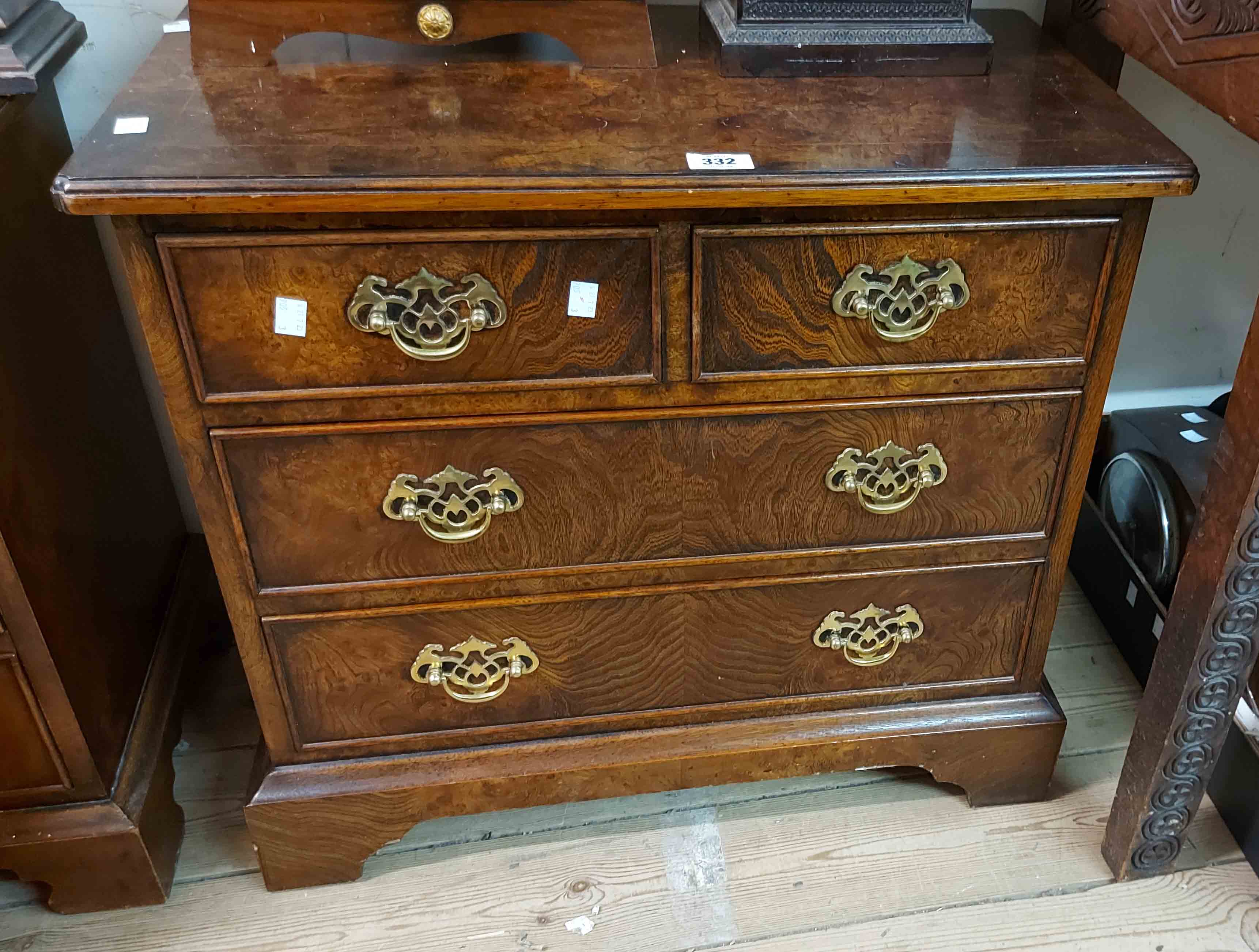 A 66cm reproduction burr walnut quarter veneered low chest of two short and two long drawers with