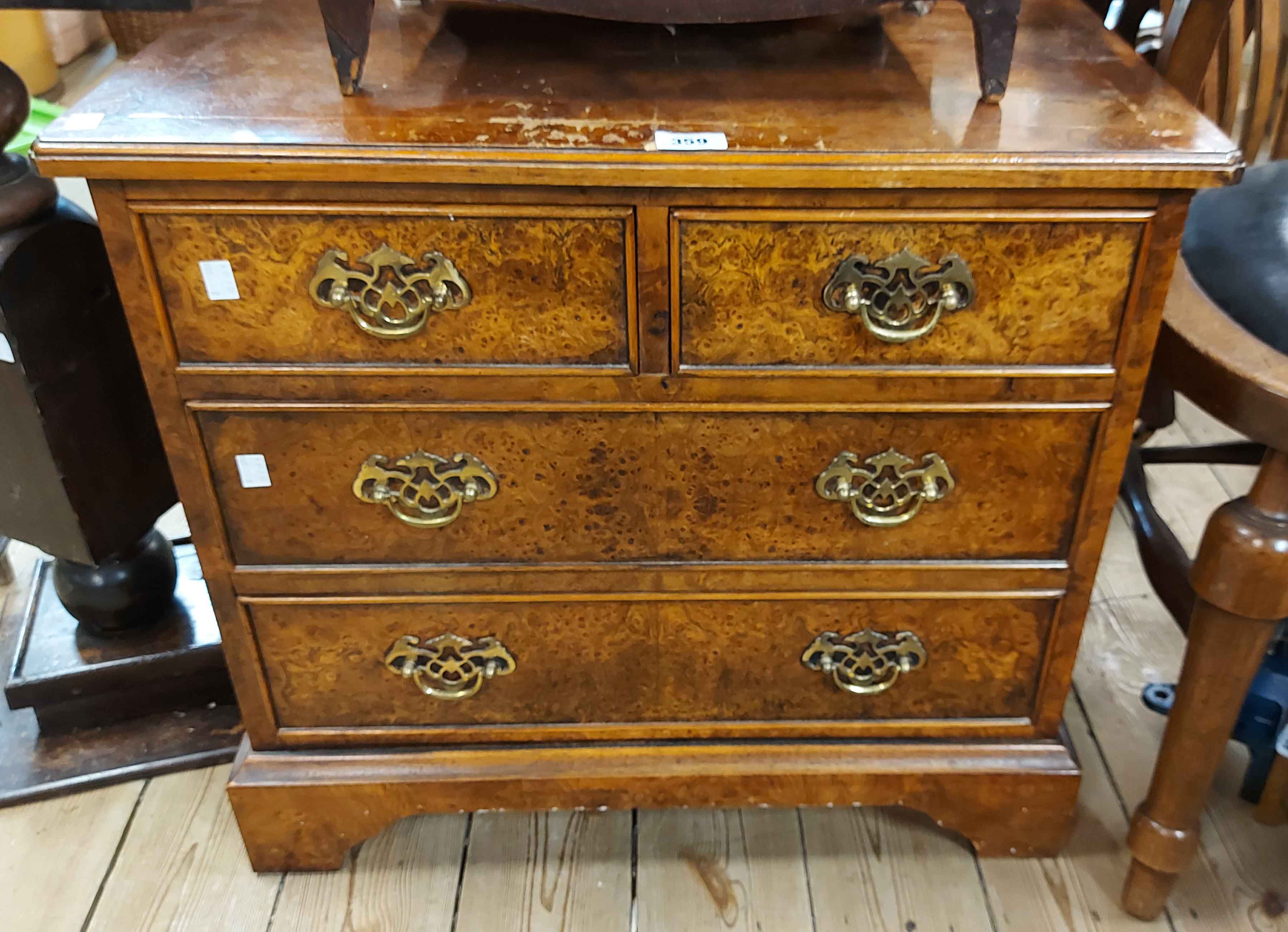 A 66cm reproduction burr walnut quarter veneered chest of two short and two long drawers with
