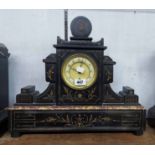 A late Victorian black slate and marble cased mantel timepiece of ornate design with incised