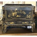 An antique Japanese lacquered box on stand with gilt decoration depicting landscape scenes and