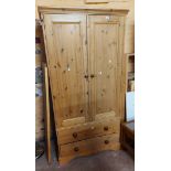 A 94cm modern pine wardrobe with hanging space enclosed by a pair of panelled doors with two drawers