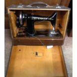 A vintage Singer electric sewing machine in hard carry case