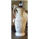 A vintage Chinese waxed plaster table lamp with moulded decoration depicting figures in a landscape