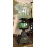 An old oil lamp, the cast iron base with bronze effect finish and green glass reservoir - sold