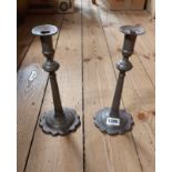 A pair of antique pewter candlesticks with crenellated bases and knopped stems