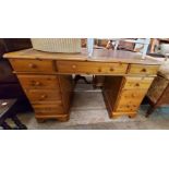 A 1.22m modern polished pine kneehole desk with brown leather inset top, three frieze drawers and