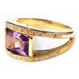 A 750 (18ct.) gold ring, set with large central oblong amethyst flanked by rows of tiny diamonds