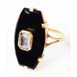 A yellow metal mourning ring with central collar set aquamarine on large shaped black onyx panel -