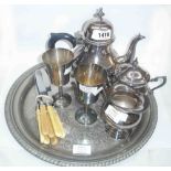 A silver plated three piece tea set on an associated tray with two goblets and small quantity of