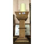 A large wooden table candlestick of squared column form