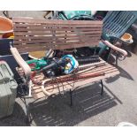 A slatted teak garden bench, set on wrought iron ends