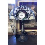 A modern cast metal table lamp with Tiffany style glass shade