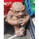 A painted concrete statue of a seated ogre