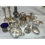 A box containing a quantity of silver plated items including hip flask, caster, candlesticks and