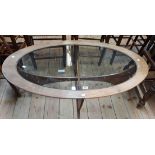 A 1.22m retro G-Plan 'Astro' teak framed oval coffee table with glass inset top and moulded cross