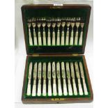 A mahogany cased set of twelve each silver plated fruit knives and forks with engraved decoration
