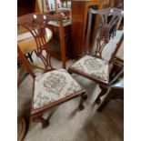 A pair of mahogany framed Chippendale style dining chairs with upholstered drop-in seats - sold with