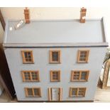 A large wooden three story doll's house of town house form with removable frontage and painted