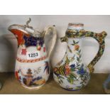 A French faience jug with polychrome floral decoration - sold with a Victorian jug with silver