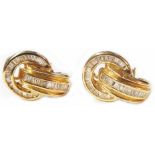 A pair of 1920's style marked 14k yellow metal and diamond encrusted earrings of hoop and loop