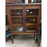 An 83cm early 20th Century quarter sawn oak book cabinet with shelves enclosed by a pair of glazed