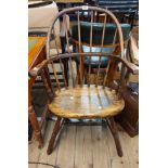 A vintage stained beech Windsor stick back bow elbow chair with moulded sectional seat, set on