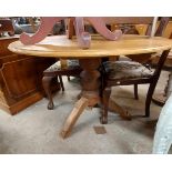 A 1.11m diameter antique pine tilt-top breakfast table, set on heavy turned pillar and tripod base -