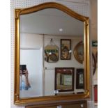 A modern antiqued gilt framed bevelled wall mirror with arched top and decorated corners