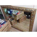 A modern bevelled oblong wall mirror with decorative vine and ribbon border - 94cm X 1.2m