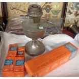 A vintage metal Aladdin table oil lamp with boxed accessories including spare mantle, chimney, etc.