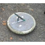 An old sun dial with hand-incised decoration and cast gnomon, set on a stone base