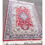 A modern handmade wool rug with central medallions and floral design within a decorative border on