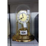 A vintage small Kein anniversary clock with ball pendulum under prespex dome